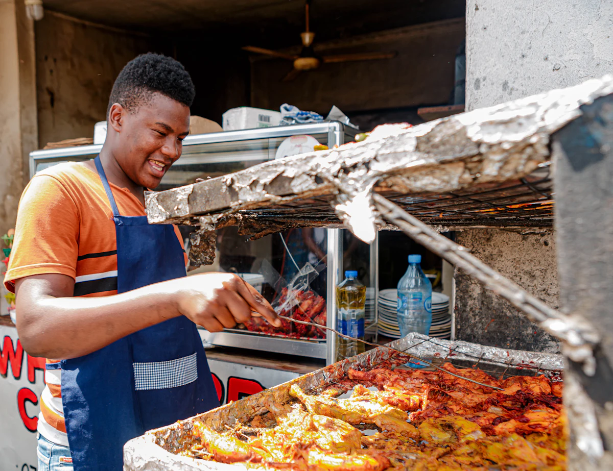 Un cuisinier souriant devant son grill